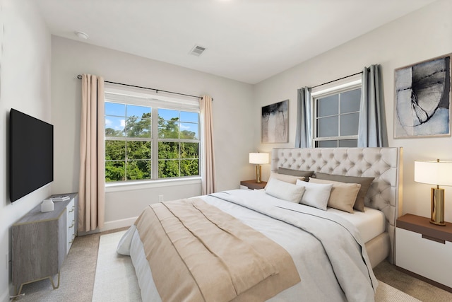 bedroom featuring visible vents and light colored carpet