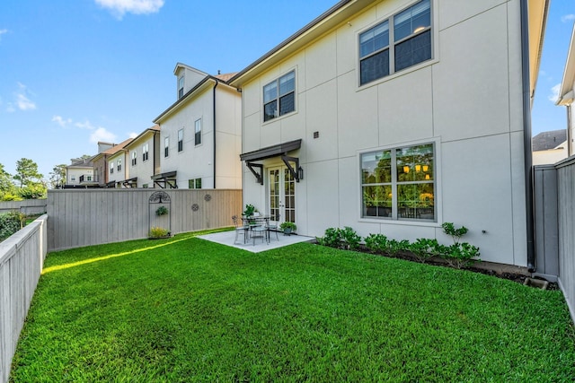 rear view of house featuring a fenced backyard, a lawn, and stucco siding