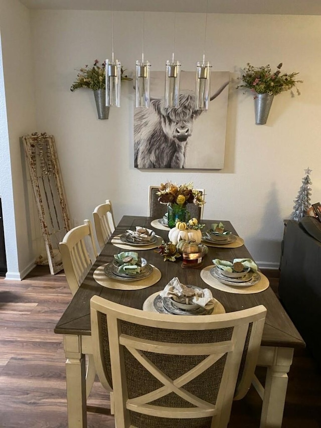 dining area with baseboards and wood finished floors