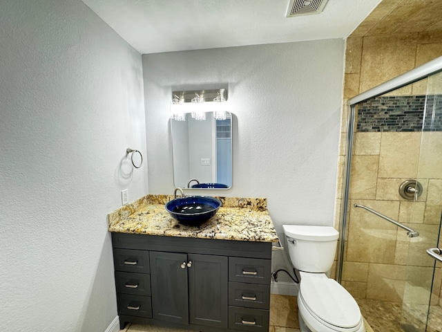 bathroom featuring visible vents, toilet, a stall shower, vanity, and baseboards