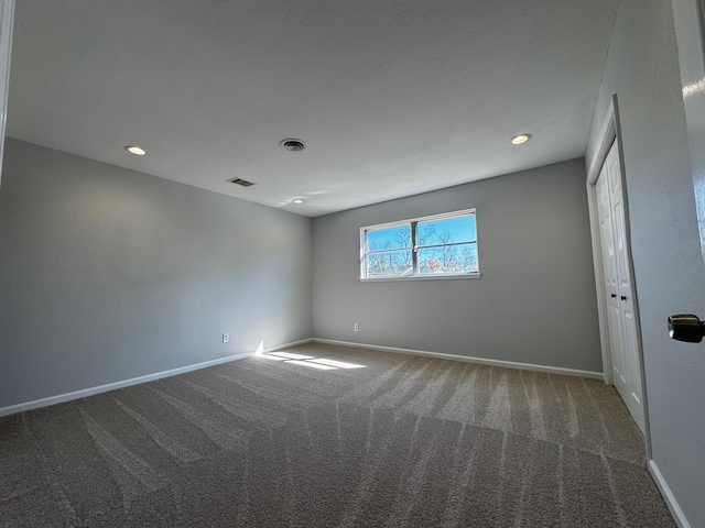 carpeted empty room with recessed lighting, visible vents, and baseboards