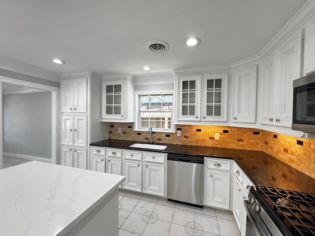 kitchen with stainless steel appliances, white cabinetry, a sink, and visible vents