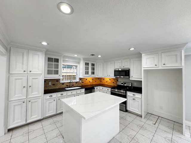 kitchen with tasteful backsplash, white cabinetry, stainless steel appliances, and a sink