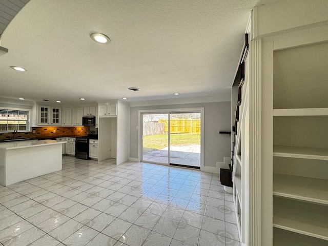 unfurnished living room featuring a textured ceiling, recessed lighting, a sink, visible vents, and baseboards