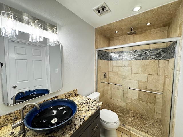 full bathroom with toilet, a stall shower, visible vents, and vanity