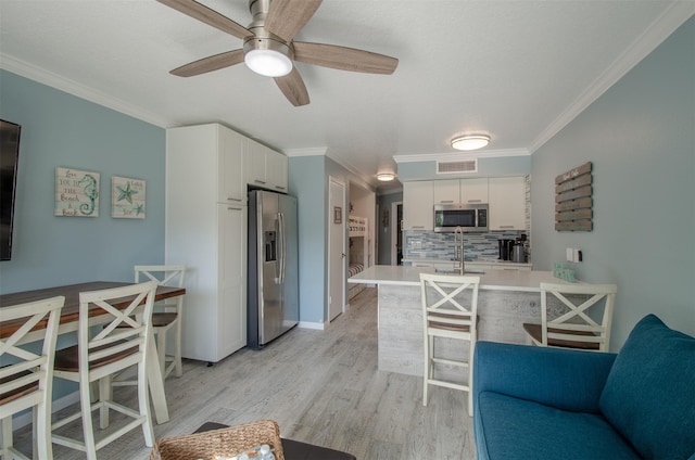 6300 Seawall Blvd Unit 9108, Galveston, TX 77551 - kitchen with light wood finished floors, white cabinetry, light countertops, and stainless steel appliances