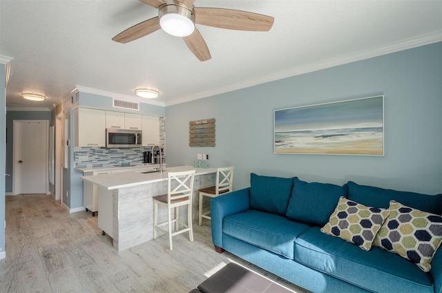 6300 Seawall Blvd Unit 9108, Galveston, TX 77551 - living area featuring light wood-type flooring, crown molding, ceiling fan, and visible vents