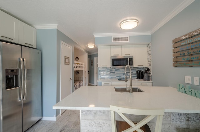 6300 Seawall Blvd Unit 9108, Galveston, TX 77551 - kitchen featuring visible vents, ornamental molding, tasteful backsplash, appliances with stainless steel finishes, and a sink