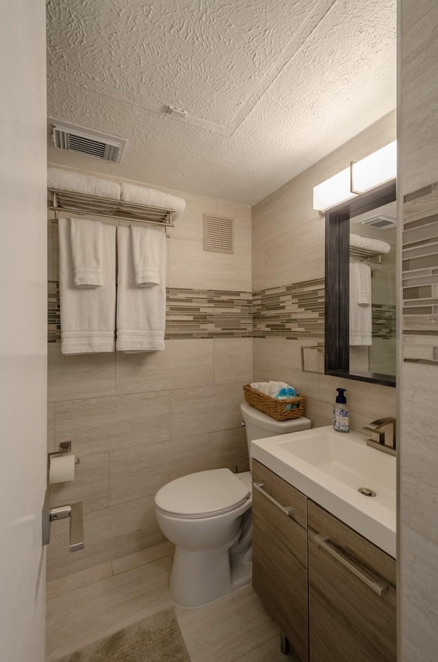 6300 Seawall Blvd Unit 9108, Galveston, TX 77551 - bathroom featuring toilet, vanity, a textured ceiling, and visible vents