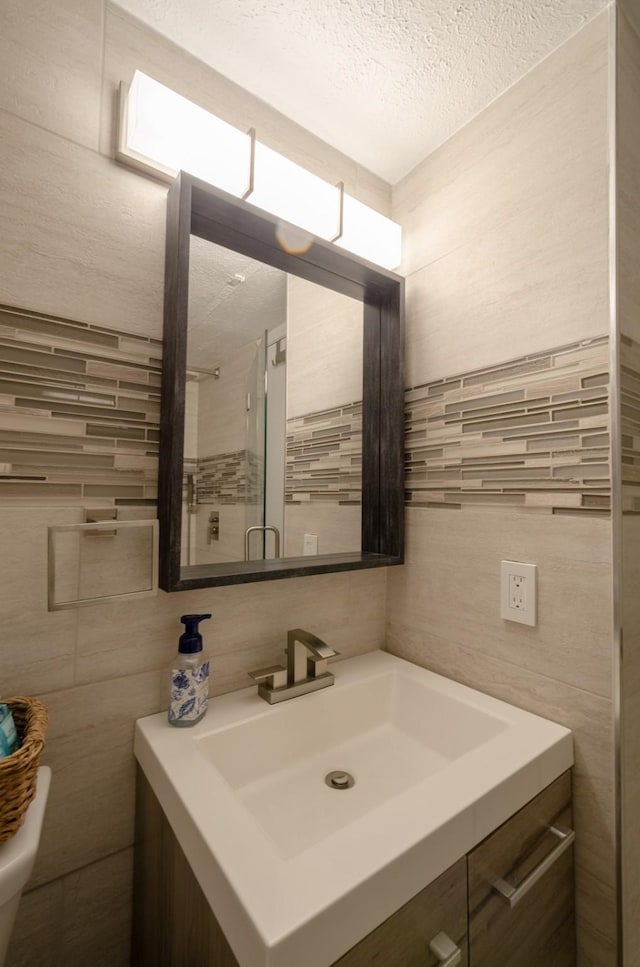 6300 Seawall Blvd Unit 9108, Galveston, TX 77551 - bathroom featuring tile walls, toilet, vanity, and a textured ceiling