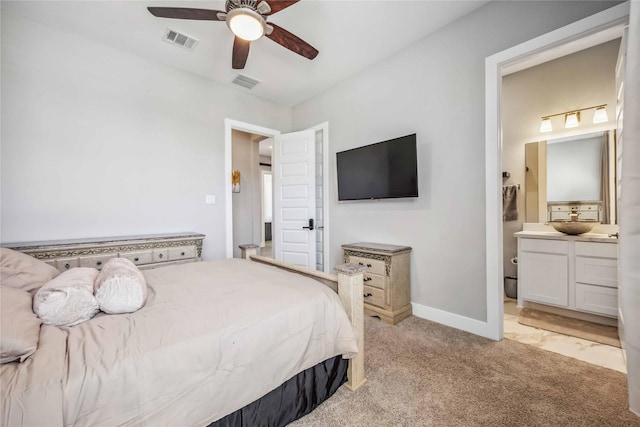 bedroom featuring baseboards, a sink, visible vents, and light colored carpet