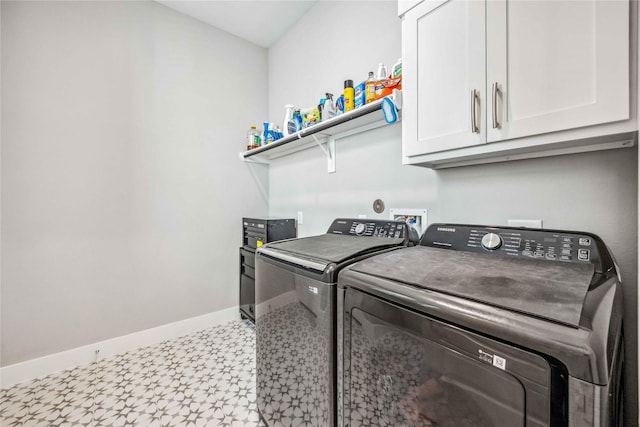 washroom featuring tile patterned floors, washing machine and dryer, cabinet space, and baseboards