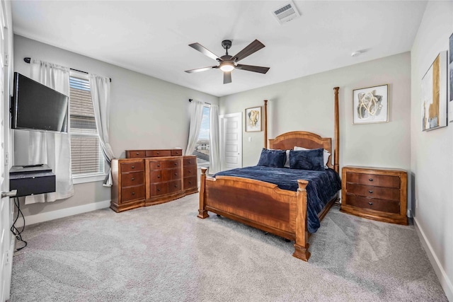 carpeted bedroom featuring a ceiling fan, visible vents, and baseboards