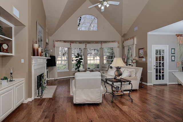 living area featuring a fireplace with flush hearth, a wealth of natural light, a towering ceiling, and wood finished floors