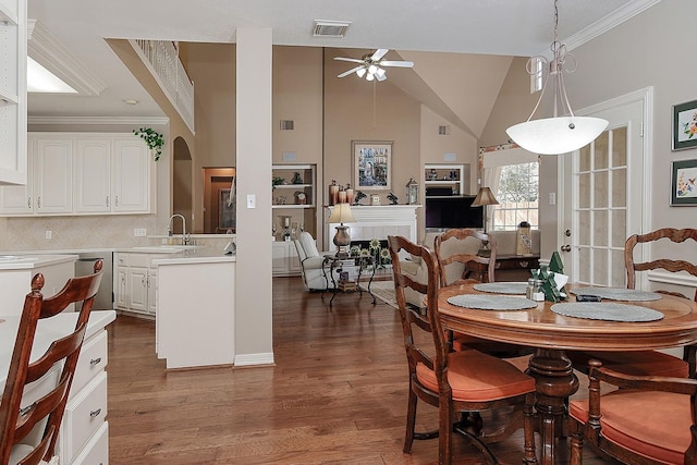 dining room with ornamental molding, dark wood-style flooring, a fireplace, and visible vents