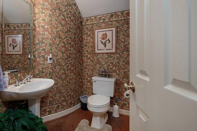 bathroom with baseboards, wood finished floors, toilet, and wallpapered walls