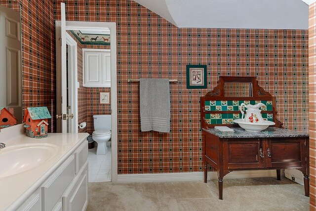 bathroom featuring toilet, vanity, and tile walls