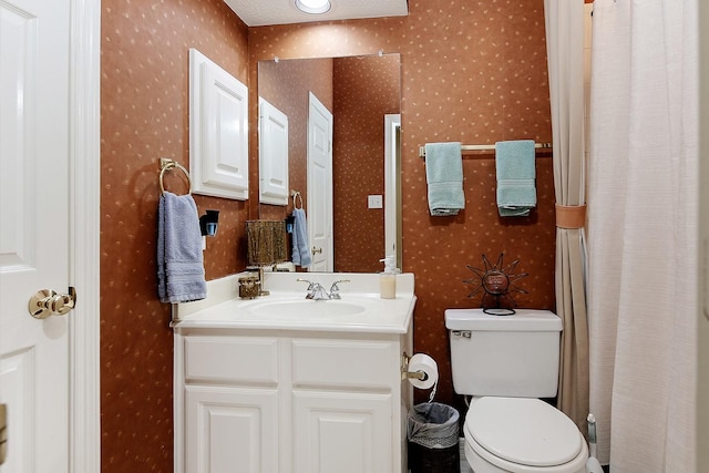 full bathroom with vanity, toilet, and wallpapered walls