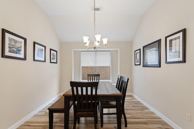 dining area featuring vaulted ceiling, light wood-style flooring, visible vents, and baseboards