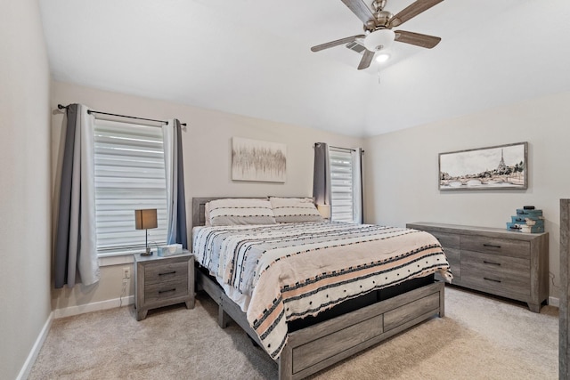 bedroom featuring a ceiling fan, light colored carpet, vaulted ceiling, and baseboards