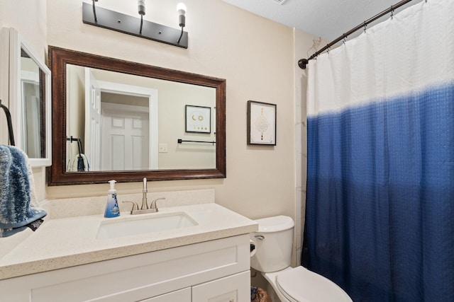 bathroom featuring toilet, curtained shower, a textured ceiling, and vanity