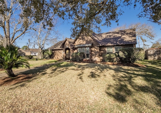 view of front of home with a front yard, stone siding, and brick siding