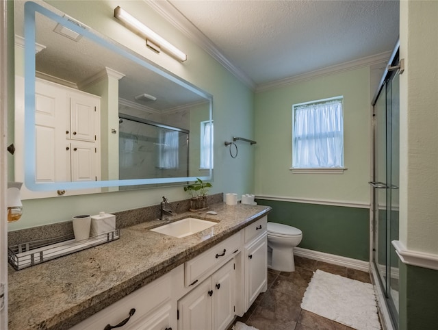 bathroom featuring toilet, ornamental molding, a shower stall, vanity, and a textured ceiling