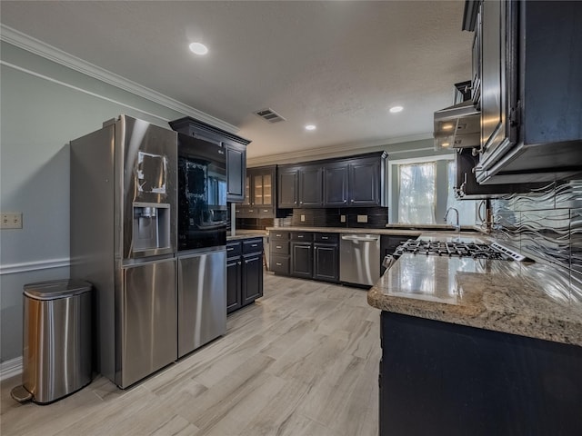 kitchen with visible vents, ornamental molding, stainless steel appliances, and backsplash