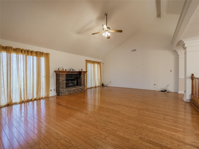 unfurnished living room with a fireplace, decorative columns, light wood finished floors, visible vents, and a ceiling fan