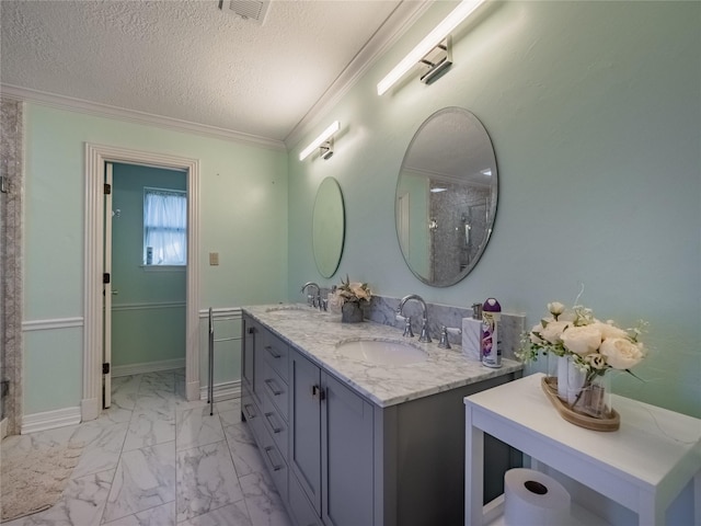 bathroom featuring a textured ceiling, marble finish floor, ornamental molding, and a sink