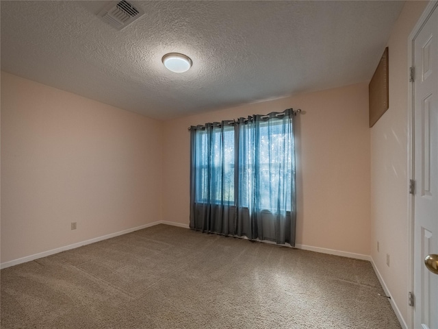 spare room with a textured ceiling, visible vents, and baseboards