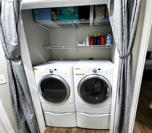 washroom with washing machine and clothes dryer, laundry area, and wood finished floors