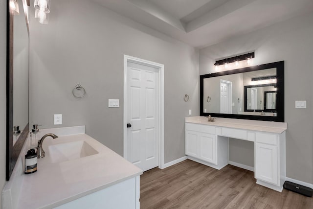 bathroom featuring vanity, baseboards, and wood finished floors