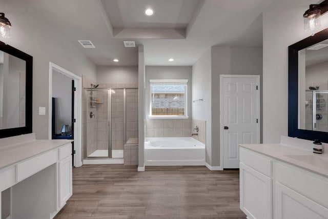 full bathroom featuring a garden tub, a stall shower, wood finished floors, and visible vents