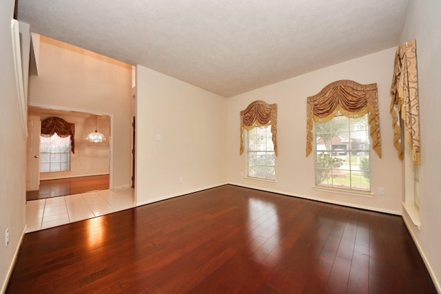 empty room with wood-type flooring and baseboards