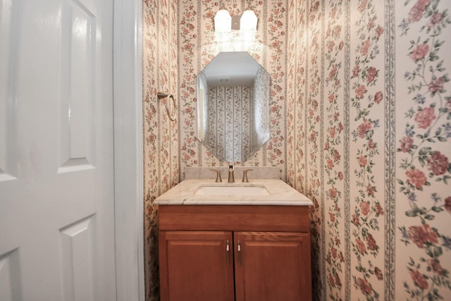 bathroom featuring vanity and wallpapered walls