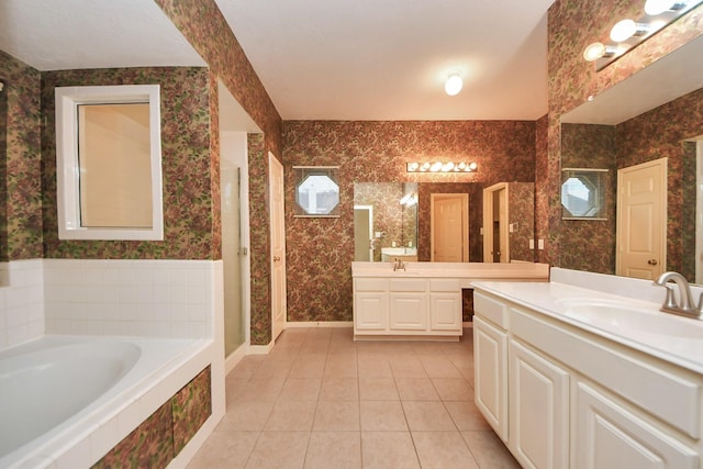 bathroom featuring a bath, wallpapered walls, tile patterned flooring, and a sink