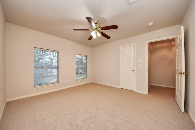 unfurnished room featuring baseboards, ceiling fan, and light colored carpet