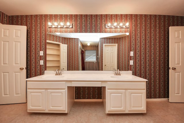 full bathroom with a sink, baseboards, and wallpapered walls