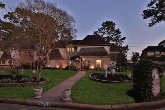 view of front of property with a front lawn and brick siding