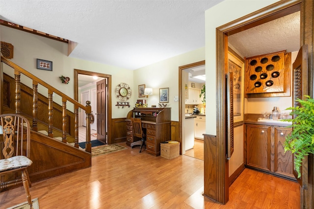 8011 Beaufort Dr, Spring, TX 77379 - interior space featuring a wainscoted wall, a textured ceiling, stairway, and light wood-style floors
