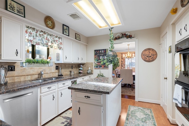 8011 Beaufort Dr, Spring, TX 77379 - kitchen featuring white cabinets, a sink, light wood-style flooring, and dark stone countertops