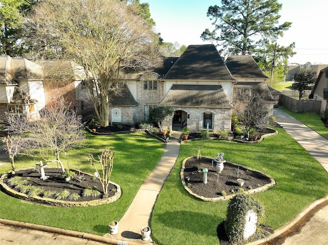8011 Beaufort Dr, Spring, TX 77379 - view of front facade with stone siding, fence, and a front lawn