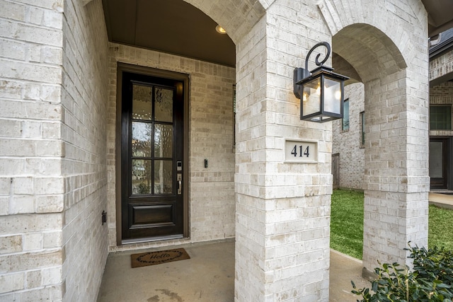 doorway to property featuring brick siding