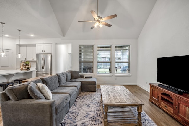 living room featuring baseboards, ceiling fan, wood finished floors, vaulted ceiling, and recessed lighting