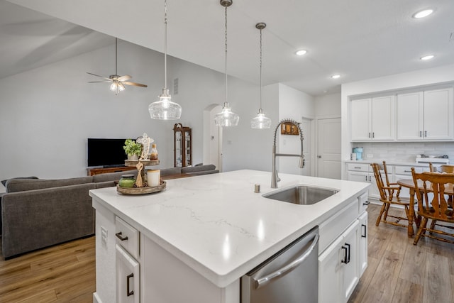 kitchen with light wood-style flooring, a sink, open floor plan, dishwasher, and tasteful backsplash