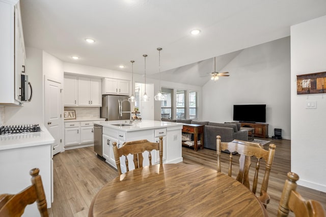 dining room with baseboards, a ceiling fan, lofted ceiling, light wood-style flooring, and recessed lighting