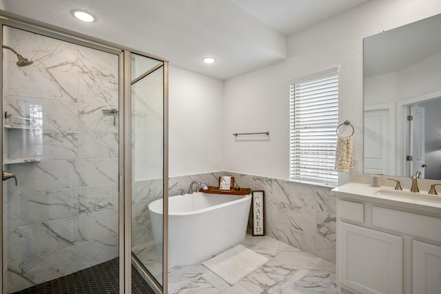 bathroom featuring a stall shower, marble finish floor, vanity, a freestanding tub, and recessed lighting