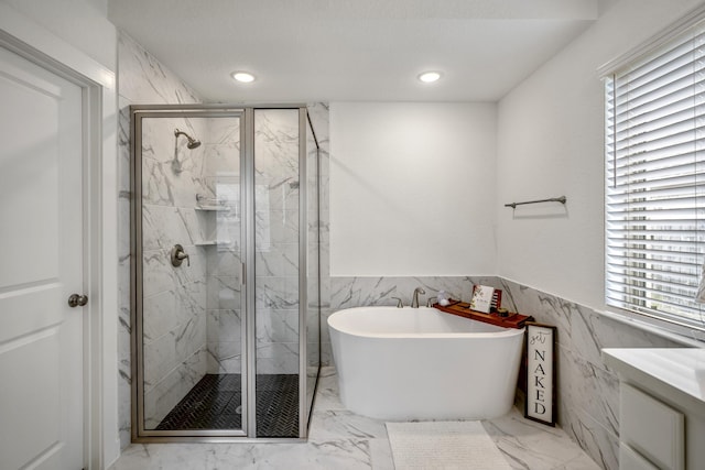 bathroom with a freestanding bath, marble finish floor, a marble finish shower, and recessed lighting