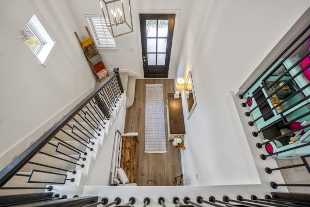 entrance foyer featuring stairway, wood finished floors, and an inviting chandelier